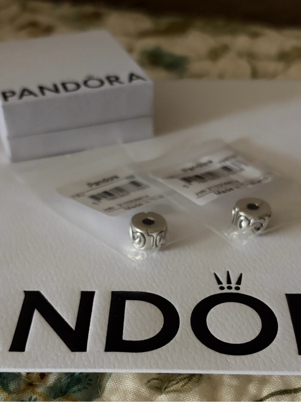 Two Pandora Knotted Hearts Clip Charms in original package.